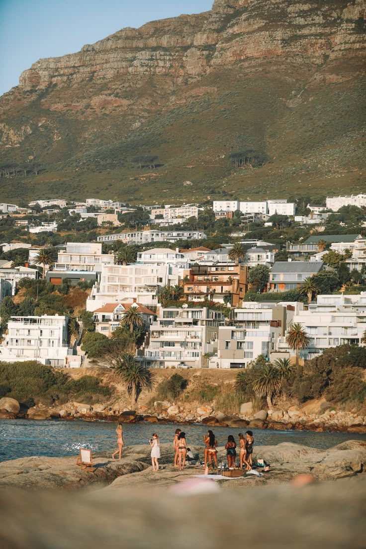 Friends gathering on the rocks beside the sea in Cape Town